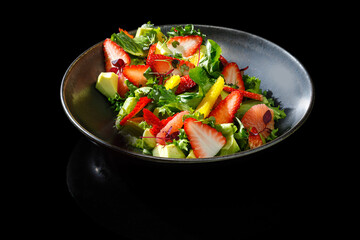 A fresh fruit and greens salad with strawberries, citrus, and avocado. Restaurant-style presentation with vibrant colors, captured under studio lighting