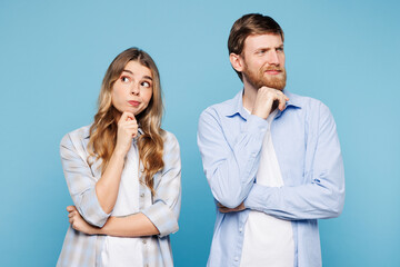 Young minded couple two friends family man woman wear shirt casual clothes together put hand prop up on chin, lost in thought and conjectures isolated on plain light blue background Lifestyle concept