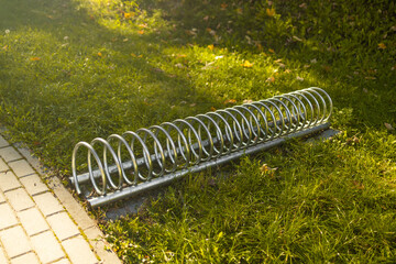 Metal bicycle parking rack in grass field. High quality photo