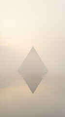 Fototapeta premium Mystical Pyramid Reflection: A solitary pyramid emerges from a misty landscape, its reflection mirrored in calm water, creating an atmosphere of mystery and timelessness.