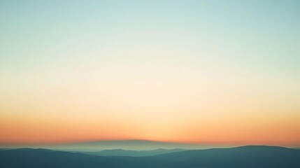 Obraz premium A serene sunrise paints the horizon with soft pastels, casting gentle hues over the tranquil layers of distant rolling hills.