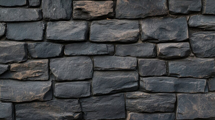 Dark stone wall texture with rough surfaces and natural patterns, ideal for backgrounds or architectural designs