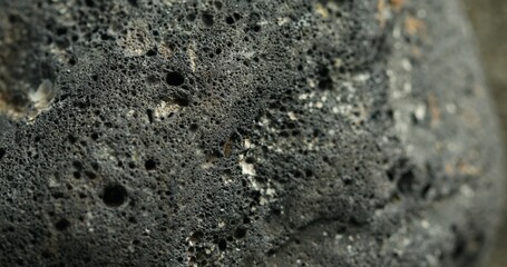 Close-up of a dark porous volcanic rock with rough texture