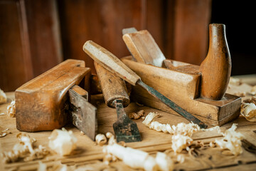 Vintage tools and wooden materials in a carpentry workshop. Hand plane with old chisel.