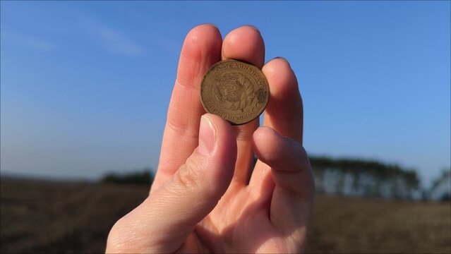 Coin collectors seek rare and unique coins, each with its distinct and value. Antique coin in hand. In hands is an old coin with a face value of 5 kopecks of the USSR in 1931.