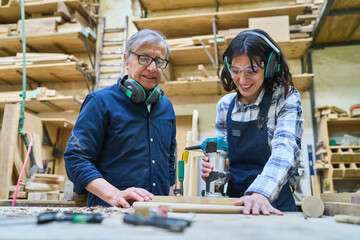 Two generations collaborating in a bustling lumberyard workshop
