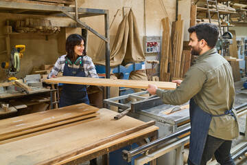 Young and older workers collaborating in a busy lumberyard