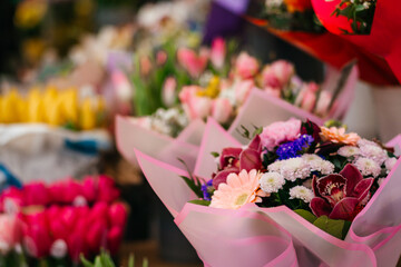 A vibrant assortment of fresh tulips in various shades of pink, purple, and peach, beautifully arranged in bouquets