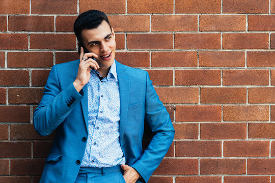 young man in blue suit on phone