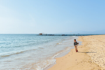 One Asian boy having fun at Xunliao Bay beach in Huizhou, Guangdong province, China, in January winter