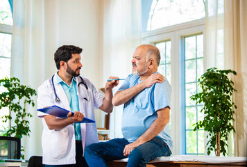 Indian Senior retired male patient undergoing physiotherapy assessment for shoulder, neck pain