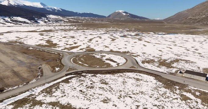 Aerial view of a roundabout in a snowy valley.