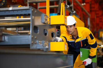 service maintenance, checking, inspection. Hispanic man worker in safety hardhat helmet at steel factory, metal sheets and industrial machinery in a large manufacturing plant.