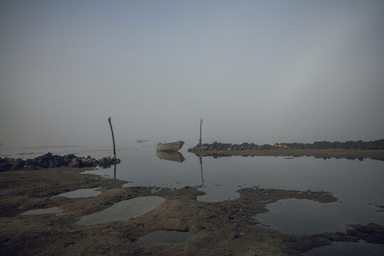 Horizontal shot of a row boat on an inlet in a misty morning