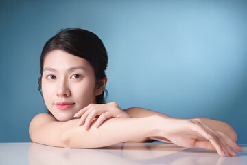 Fototapeta premium Female portrait with serene expression against a light blue background showcasing natural beauty and calm demeanor