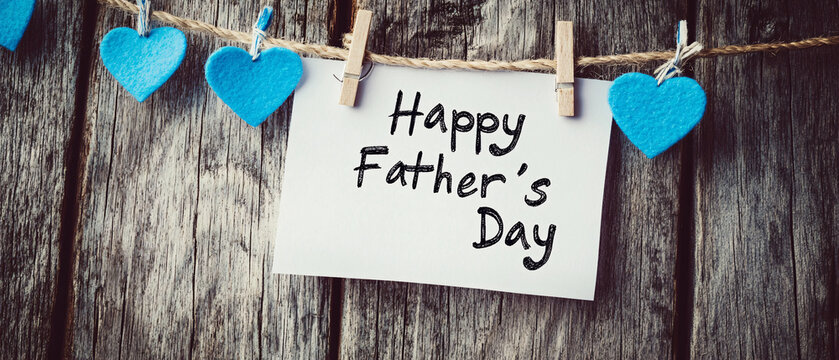 A heartfelt Father&rsquo;s Day card pinned to a rustic wooden background with decorative blue hearts symbolizing love and appreciation  
