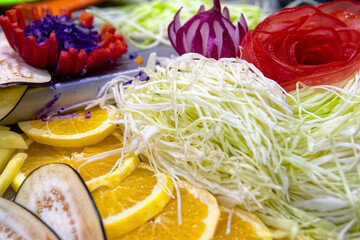 Various shredded grated chopped fresh vegetables and fruits as salad ingredients top view. Healthy eating concept.