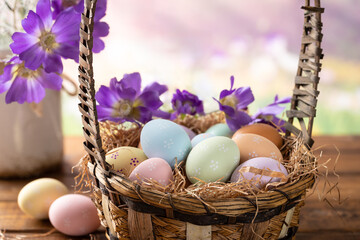 Easter eggs and flowers in a basket with springtime background