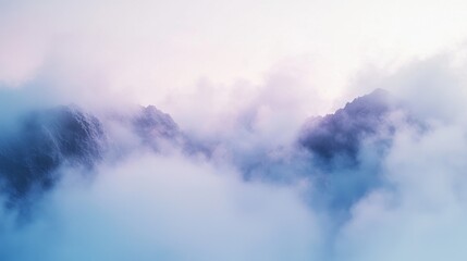 Obraz premium A serene landscape of misty mountains enveloped in soft clouds, creating a calming and ethereal atmosphere.