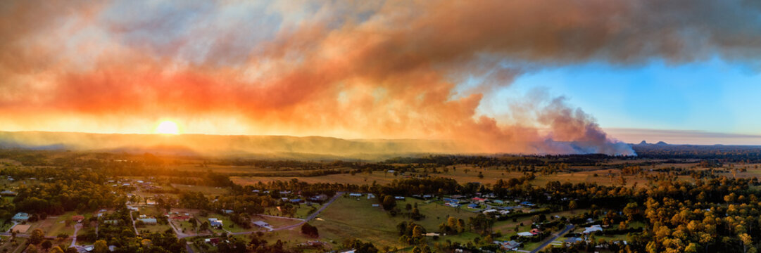 Panorama of fields and town at sunset with dramatic sky of bushfire smoke