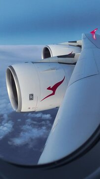 Wing with engines of Airbus A380 Qantas Airlines during flight above the clouds