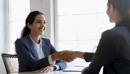 Happy young business woman bank manager handshaking client at meeting. Smiling female hr hiring recruit at job interview 