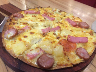 Asian style  pizza with mozzarella ham and pineapple in wooden plate and table