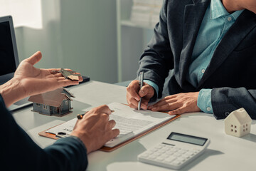 Close-up of businessman discussing contract with real estate agent for home insurance consultant...