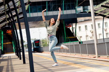 Young woman enjoying a carefree moment outdoors in the sunlight while exploring urban city streets