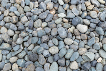 A pile of pebbles stacked against the background grain
