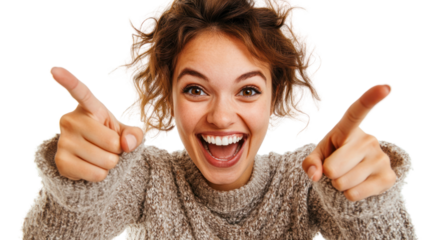 Happy young woman expressing excitement and joy, pointing fingers with a wide smile, wearing a cozy sweater against a white isolated background.