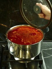 a saucepan with Ukrainian borscht is on the gas stove in the kitchen