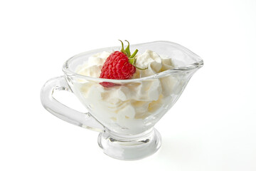 sweet red raspberries with cream in a gravy boat isolated on white background