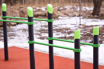 Fototapeta premium Row of green and black poles sit on top of snowy ground, great for winter or outdoor scenes.