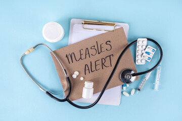 Hospital doctor notebook, with measles diagnosis, pills, vaccine or medicine syringes, stethoscope,...