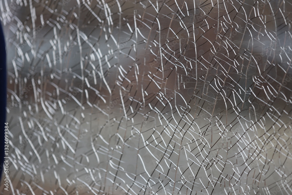 Poster A close-up view of a broken glass window with cracks and shards.