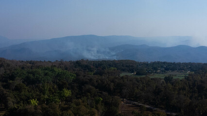 Naklejka premium Aerial view of forest fires and smoke in the forests of Thailand. Natural disaster. Burning fields in summer. Environmental destruction.
