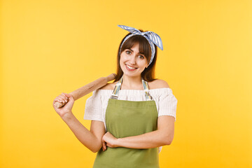 Happy woman with rolling pin on yellow background