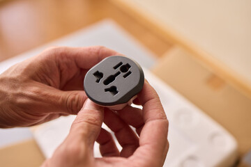 Hands Grasping a One-of-a-kind Electrical Socket Adapter for Various Uses and Applications