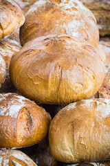 Fresh traditional loaves of wheat or rye bread on stall or in bakery