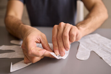 A gloved hand prepares to perform a care procedure safely and professionally in healthcare