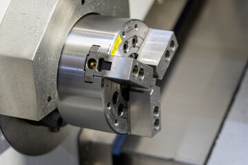 
A detailed close-up of a three-jaw chuck on a CNC machine tool, highlighting precision engineering and metal manufacturing technology.

