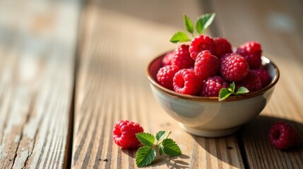 Summer Sunlight Illuminates a Bowl of Fresh Raspberries, Garnished with Mint Leaves, Resting on a Rustic Wooden Table
