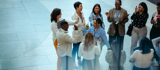 Diverse group of employees celebrating success while networking and building strong colleague...