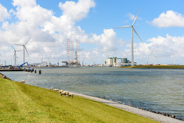 Tall wind turbines around a harbour in north east of the Netherlands on a sunny summer day