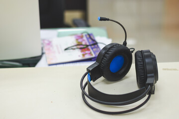 Black headphones are placed on the desk.