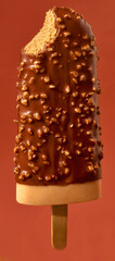 Nougat Stieleis mit Haselnusstuecken und Anbiss, Eiscreme, Eis am stiel, Schokolade, Nusskrokant, 