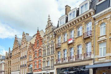 Fototapeta premium Historic residential buildings with shops on ground level in Belgium on a partly cloudy summer day