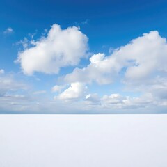 A blue sky above a vast expanse of untouched snow with fluffy white clouds drifting lazily by, clean, open, landscape