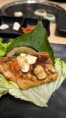 Eating Korean-style grilled meat consisting of meat and vegetables.